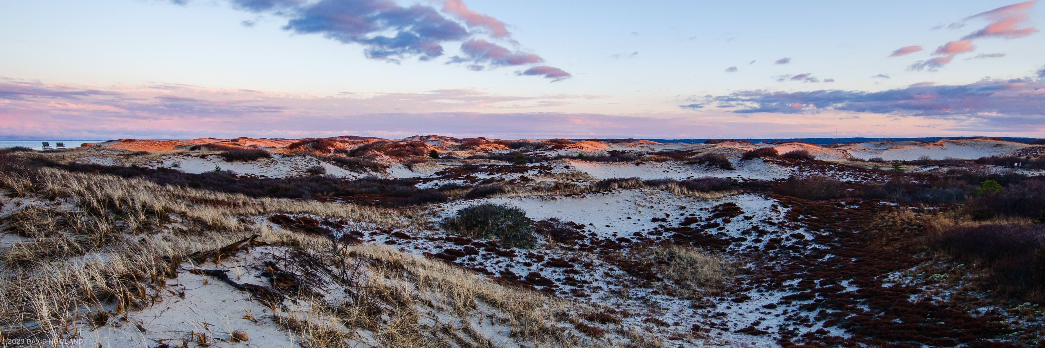 A panorama photo of sunset over the expansive sand dunes of Sandy Neck Beach Park