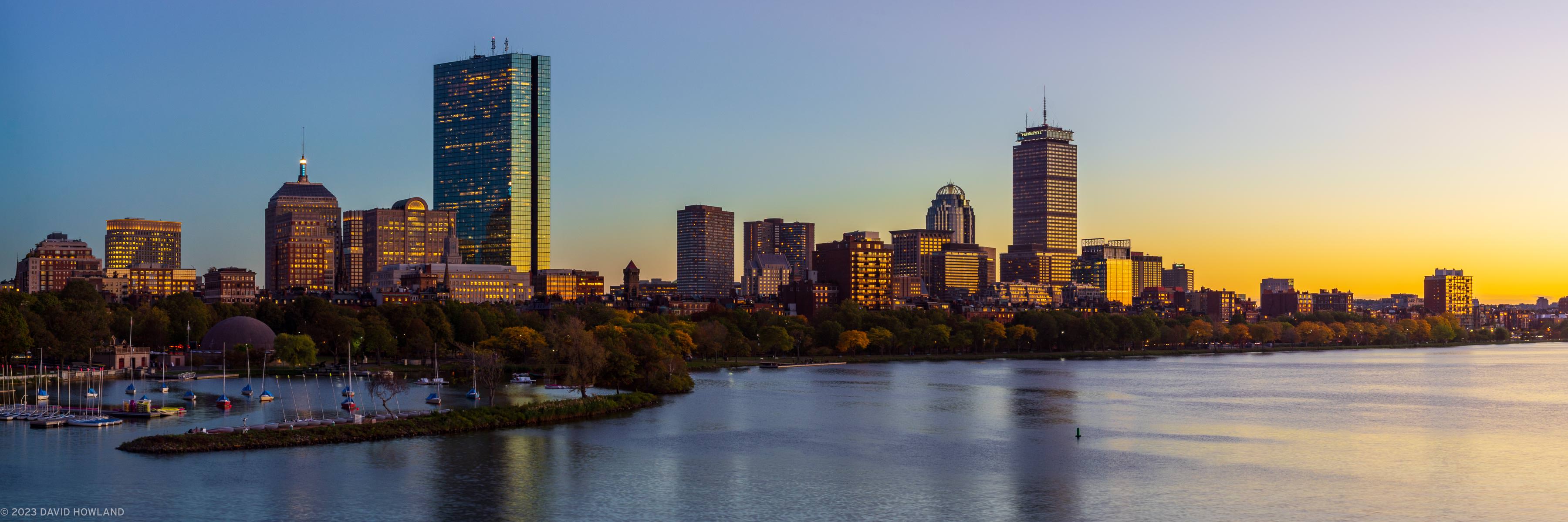 A panorama photo of the illuminated buildings of the Back Bay neighborhood of Boston at sunset.